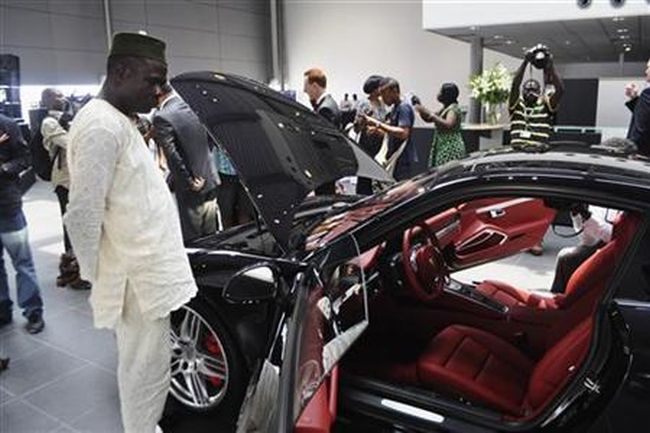 Un homme nigérian admirant un véhicule Porsche dans la salle d'exposition de Lagos le 14 mars 2012 | Credit Photo : Reuters/Monica Mark